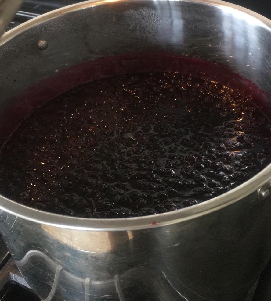 pot with blackcurrant boiling for jam